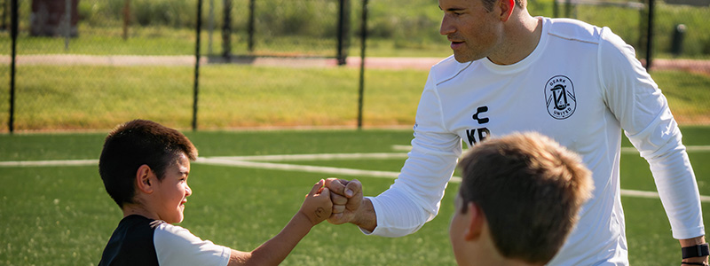 Ozark United FC coach and youth soccer player fist bump