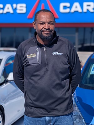 Dishawn Bell, GM of America’s Car-Mart of Conway, Ark., standing in front of inventory.